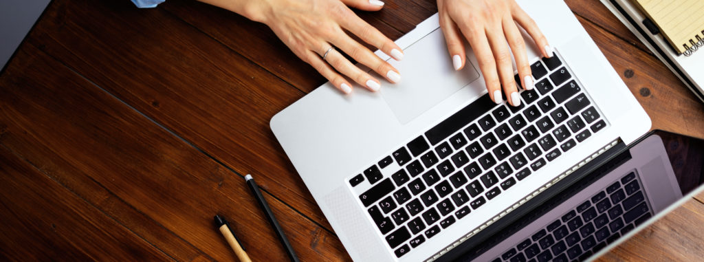 Closeup photo of female hands with a laptop. Female freelancer c