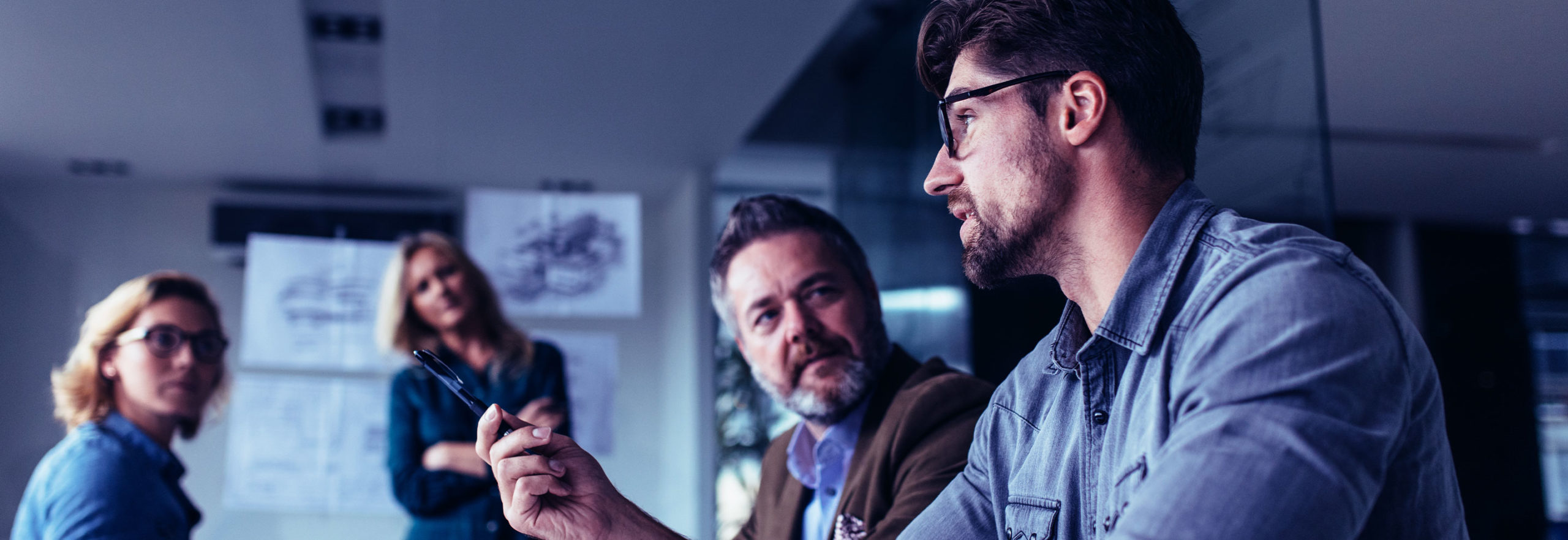 Four people in a meeting discussing something seriously