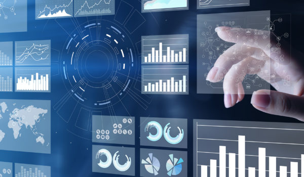 A white woman's hand is pointing from the right side of the screen to a futuristic transparent wall or screen of various data charts. There are doughnut charts, bar charts and other types.