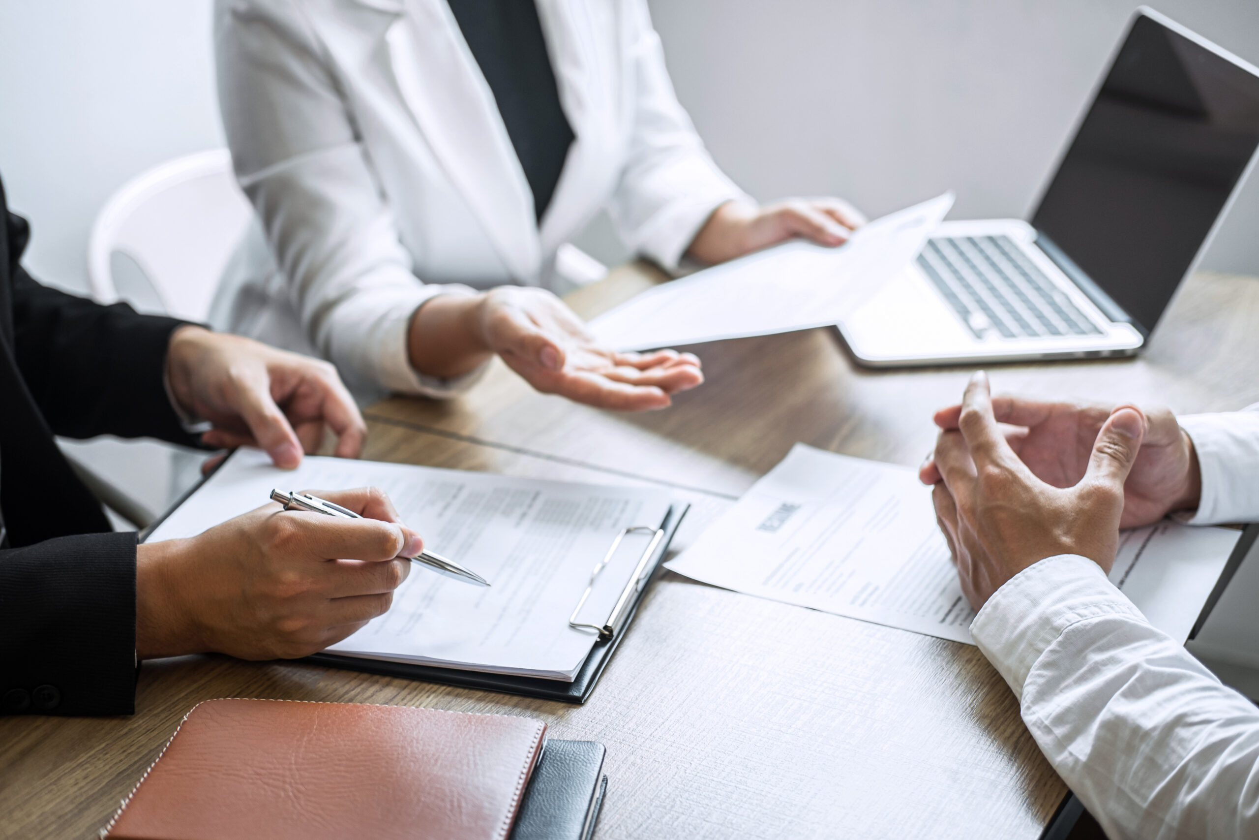 Employer or committee holding reading a resume with talking during about his profile of candidate, employer in suit is conducting a job interview, manager resource employment and recruitment concept.