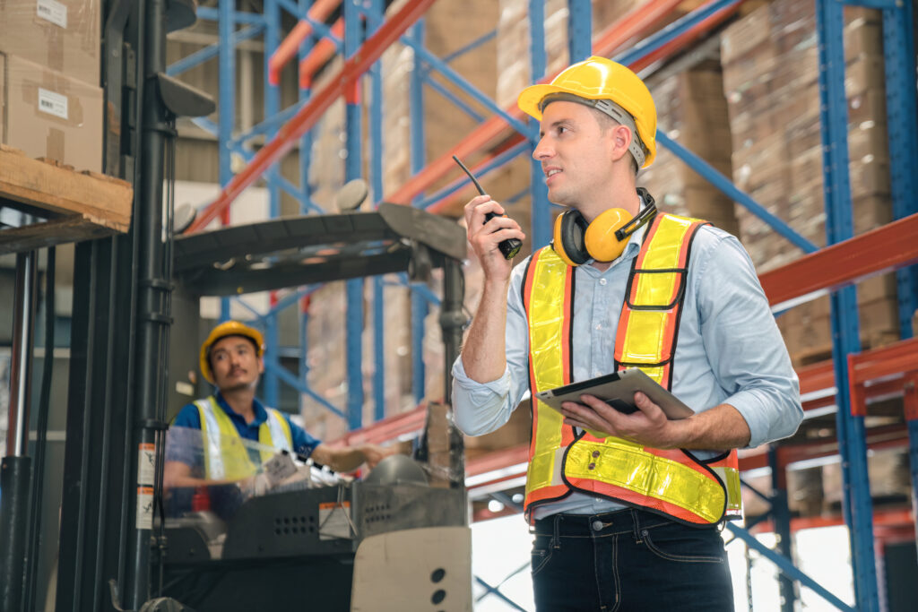 White warehouse man,manager use digital tablet check package with worker forklift driver loading box on shelf, product distribution inventory management, Logistics shipping business planning